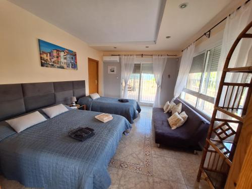 a bedroom with two beds and a couch at Villa Casa Kenaz in El Campello