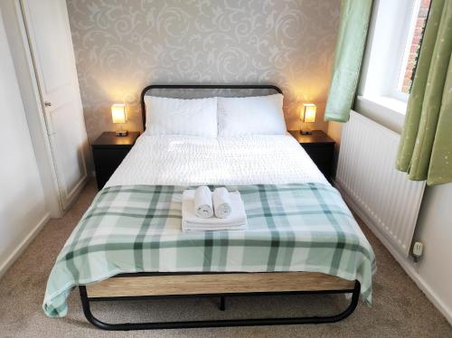 a bedroom with a bed with two towels on it at The Swans - Two-Bedroom City Centre House with Parking in Oxford