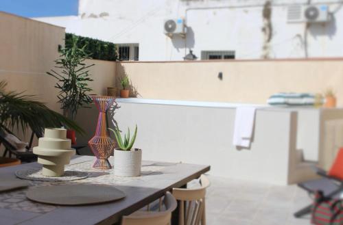 a patio with a table with vases and plants on it at Hostal Benalup Atalaya in Benalup Casas Viejas