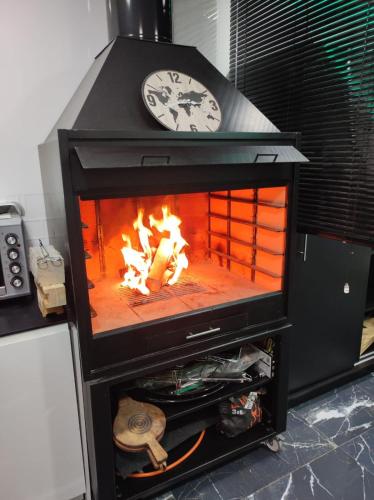 a fireplace with a clock on top of it at IN LOVE in Mahora