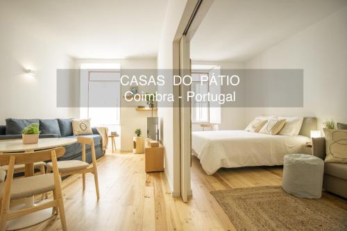 a bedroom with a bed and a living room at Casas do Pátio in Coimbra