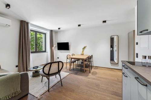 a kitchen and living room with a table and chairs at Limehome Bad Hall Hauptplatz in Bad Hall