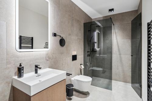 a bathroom with a sink and a toilet and a shower at Limehome Bad Hall Hauptplatz in Bad Hall
