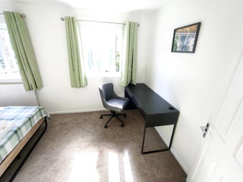 a bedroom with a desk and a bed and a window at The Swans - Two-Bedroom City Centre House with Parking in Oxford