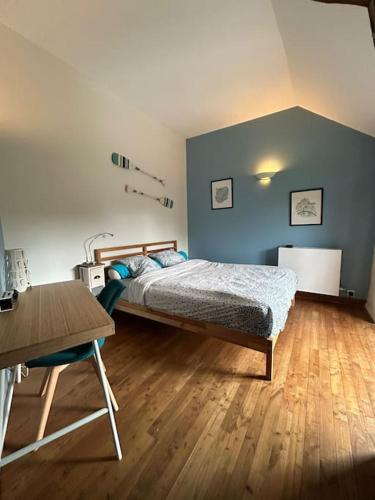 une chambre avec un lit et un parquet dans l'établissement Maison privée à Brocéliande, à Saint-Malon-sur-Mel
