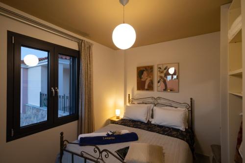 a bedroom with a bed and a large window at Lampetos Houses Molyvos in Mithymna