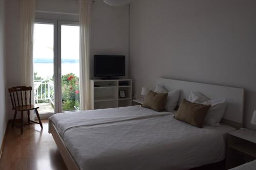 a bedroom with a bed with a television and a window at Apartments Fink in Portorož