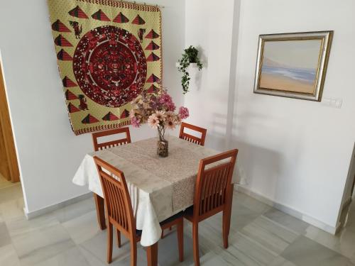 a dining room table with a vase of flowers on it at Apartamento Plaza Nueva del Morche in Morche