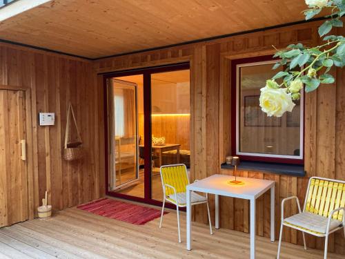 a room with a table and chairs on a deck at Stadtfüchse plus Sauna in Bad Ischl
