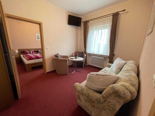 a living room with a couch and a bed at Hotel Zur Mosel in Minheim