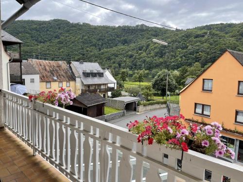 a balcony with flowers on it with a town at Hotel Zur Mosel in Minheim