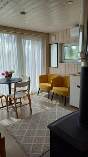Una sala de estar con sillas amarillas y una mesa. en Pieni Mökki, en Kuusalu