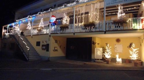 a building with christmas lights on the side of it at Hotel Zur Mosel in Minheim