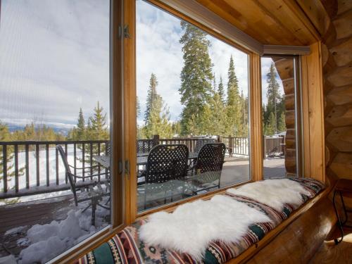 a window in a cabin with a view of a deck at Miles Behind Log Cabin in Fraser