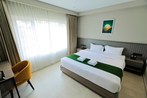a hotel room with a large bed and a window at Mount Land in Sultan Bathery
