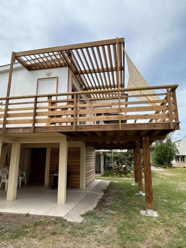 a house with a deck on top of it at Maison Chalet 200 m de la plage climatisation et Wifi in Gruissan