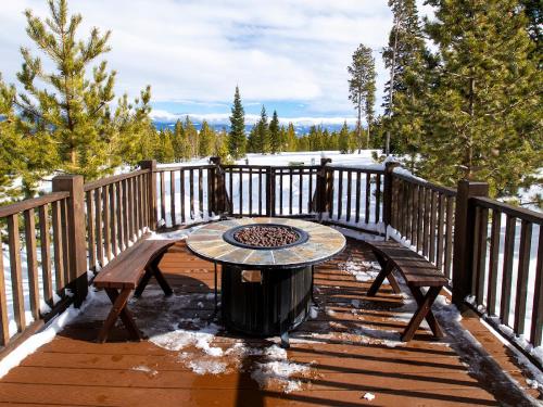a wooden deck with a table and a fire pit at Miles Behind Log Cabin in Fraser