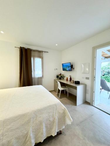 a bedroom with a bed and a desk and a window at Villa Berenike in San Teodoro