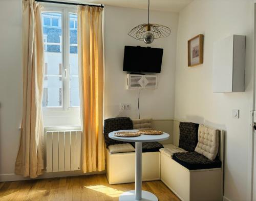 a small living room with a table and a chair at Cosy Appart - Plage à 2min - Casino à 1min in Trouville-sur-Mer
