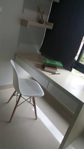 a white chair sitting in front of a desk at JK LIVING Hotel And Service Apartment in Chachoengsao