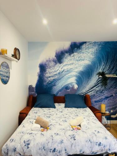une chambre avec un grand tableau d'une vague sur le mur dans l'établissement Cosy Appart - Plage à 2min - Casino à 1min, à Trouville-sur-Mer