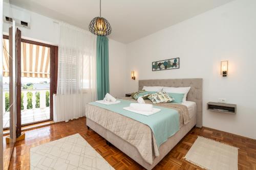 a bedroom with a bed and a large window at Tinel Apartment Sukosan in Sukošan