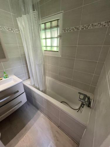 une salle de bain avec une baignoire et un lavabo dans l'établissement Chalet au Pla d'Adet, à Saint-Lary-Soulan