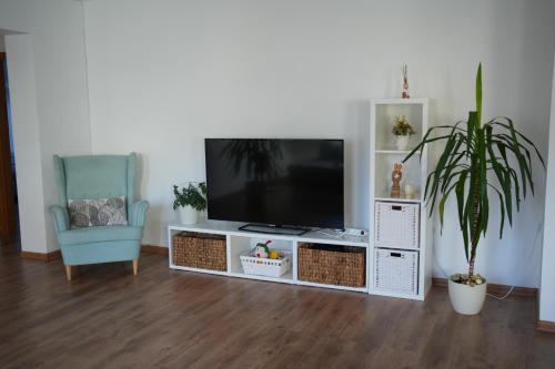 a living room with a flat screen tv and a blue chair at Ubytování U Pivovaru in Kamenice nad Lipou