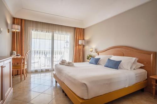 a bedroom with a large bed and a large window at Palace Hotel Desenzano in Desenzano del Garda
