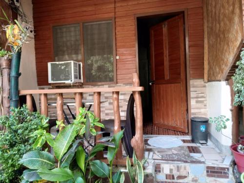 a porch of a house with a microwave on it at ALFA Garden Lodge in El Nido