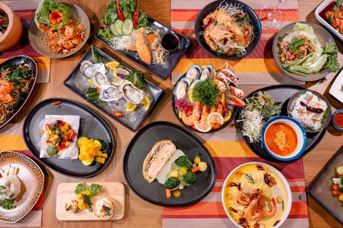 a table with many plates of food on it at Aloft Bangkok - Sukhumvit 11 in Bangkok