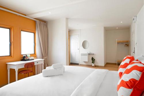 a large white bedroom with a desk and a bed at Horange Phuket Town in Phuket Town