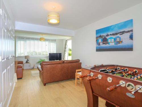 a living room with a couch and a pool table at Mor Glas in Abersoch