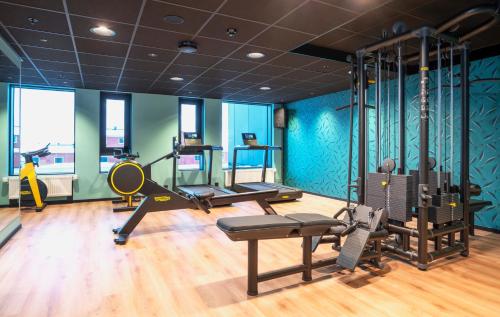 a gym with exercise equipment in a room with blue walls at Thon Hotel Svolvær in Svolvær