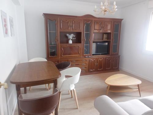 a dining room with a table and chairs and a cabinet at Aroa's Home -Sirimiri Apartments- in Zumaia