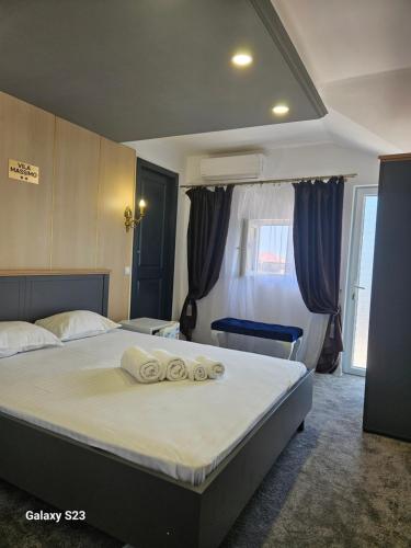 a bedroom with a bed with two towels on it at Vila Massimo in Eforie Nord