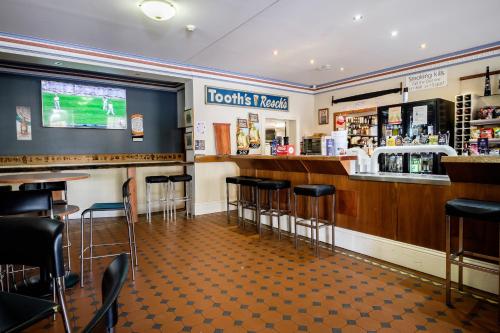a bar at a sports tavern with stools at Peel Inn Hotel Nundle in Nundle