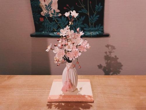a vase with pink flowers in it on a table at suikakan heianjingumae 酔花間 in Kyoto