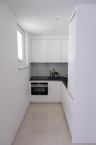 a white kitchen with white cabinets and a window at Apartment Milla in Tomislavgrad