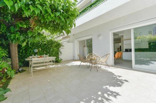 d'une terrasse avec une table, des chaises et un arbre. dans l'établissement First floor apartment walk to beach garage, à Cannes