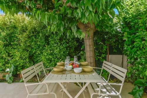 une table blanche avec des bols et des vases dessus dans l'établissement First floor apartment walk to beach garage, à Cannes