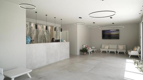 a lobby with tables and chairs and a reception desk at TUISuneo La Conchiglia - Adults Only in Capo Vaticano