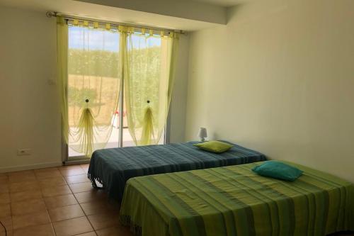 une chambre avec deux lits et une fenêtre avec des rideaux dans l'établissement Cozy cocoon just a stone's throw from the sea, au Pouliguen