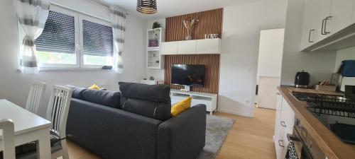 a living room with a couch and a kitchen at RingPeace Apartment, Dubrava - free parking in Zagreb