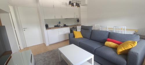 a living room with a blue couch and yellow pillows at RingPeace Apartment, Dubrava - free parking in Zagreb