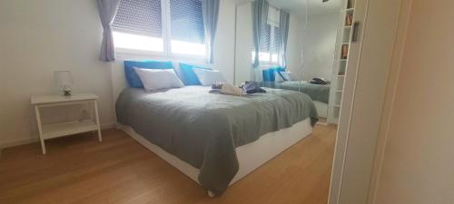 a bedroom with a bed with blue and white pillows at RingPeace Apartment, Dubrava - free parking in Zagreb