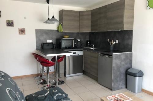 une petite cuisine avec un comptoir et un micro-ondes dans l'établissement Cozy nest close to the sea, au Pouliguen