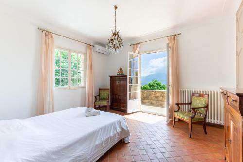 une chambre avec un lit et une grande fenêtre dans l'établissement Happyfew La villa Gattieres, à Gattières