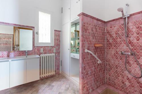 La salle de bains est pourvue d'une douche et de carrelage rouge. dans l'établissement Happyfew La villa Gattieres, à Gattières
