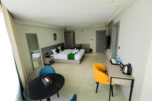 a hotel room with a bed and a table and chairs at Mount Land in Sultan Bathery
